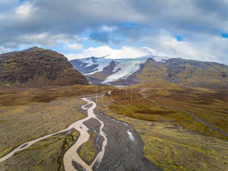 Foto de "Glaciar Vatnajoekull en Islandia que derrite el agua del glaciar que forma el río y corta a través de la tierra de la hierba" - Imagen libre de derechos