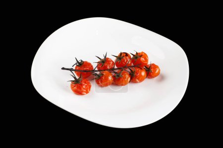 Téléchargez les photos : "tomates cuites au four sur une branche dans une assiette blanche" - en image libre de droit
