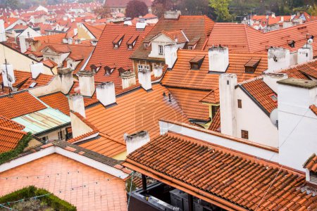 Téléchargez les photos : "Red roof of buildings in Prague in a cold cloudy fall weather. Old town of Prague with tiled roofs. Red roofs. Europe." - en image libre de droit