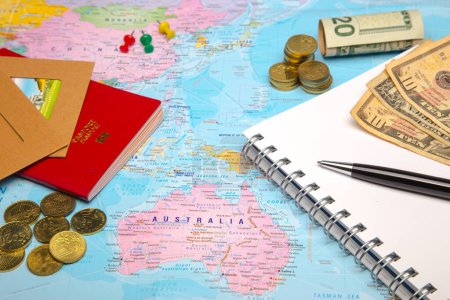 Photo for World map with money, magnifying glass and notepad - Royalty Free Image