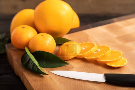 Photo for Sliced orange and other fruits on a wooden cutting board - Royalty Free Image