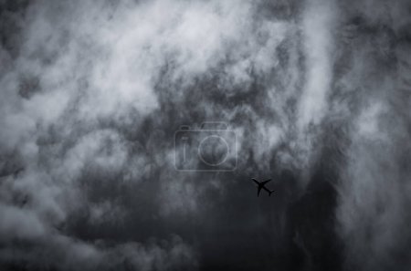 Foto de Avión volando en el cielo oscuro y nubes blancas. Aerolínea comercial - Imagen libre de derechos