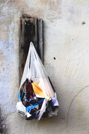 Photo for Torn bag with old books hangs on a wooden perch - Royalty Free Image