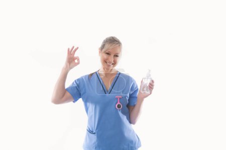 Foto de Enfermera recomendando uso de desinfectante de manos alcohol frotar para la higiene de las manos - Imagen libre de derechos