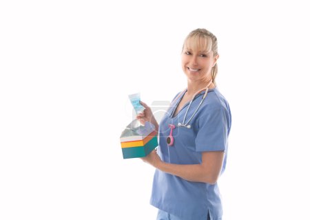 Photo for Smiling nurse holding a box of surgical medical masks - Royalty Free Image