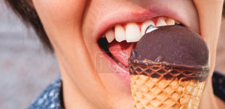 Foto de El hombre de camisa azul está comiendo helado. Foto de primer plano del postre frío. Diversión de verano
. - Imagen libre de derechos