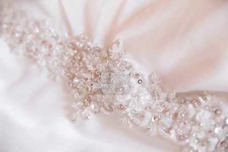 Téléchargez les photos : Broderie de perles sur robe de mariée en soie. Taille de robe brodée de perles. - en image libre de droit