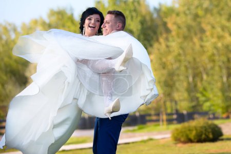 Photo for The bridegroom holds the bride in her arms.The bride and groom are happy - Royalty Free Image