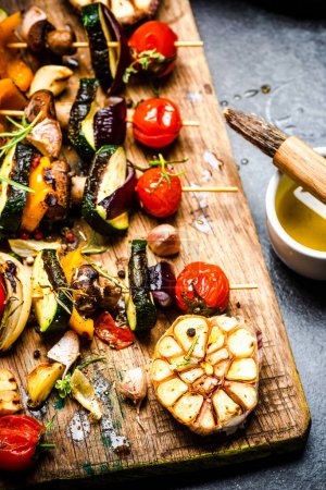Photo for "Serving Grilled BBQ Vegetables Skewers with Fresh Herbs" - Royalty Free Image