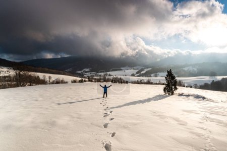Foto de Hombre activo de pie en la montaña nevada al amanecer en Bieszczady - Imagen libre de derechos