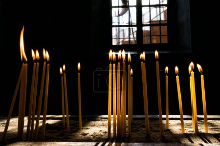 Téléchargez les photos : Bougies dans l'église chrétienne sombre - en image libre de droit