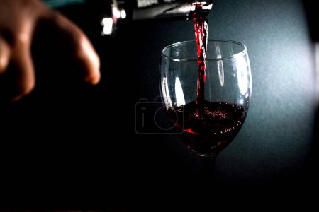 Téléchargez les photos : Verser du vin rouge dans un verre - en image libre de droit