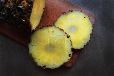 Téléchargez les photos : Ananas tranché sur une planche de bois - en image libre de droit