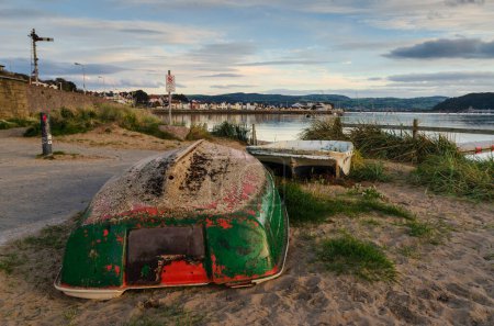 Téléchargez les photos : Un bateau à rames renversé sur la plage - en image libre de droit