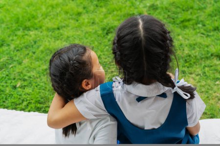 Téléchargez les photos : Deux petites filles asiatiques sœurs câlins heureux post en uniforme scolaire - en image libre de droit