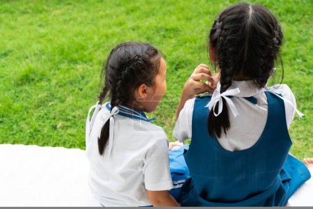 Foto de Dos poco asiático niñas hermanas abrazando feliz post en escuela uniforme - Imagen libre de derechos