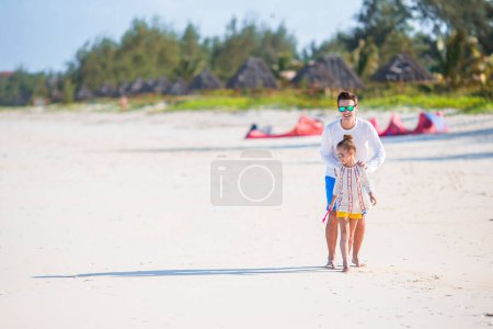 Téléchargez les photos : Petite fille et papa heureux s'amuser pendant les vacances à la plage - en image libre de droit