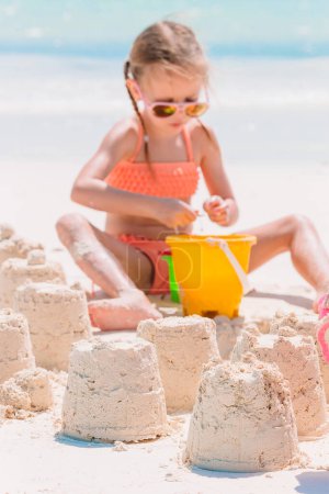 Foto de Niña en la playa tropical blanca haciendo castillo de arena - Imagen libre de derechos