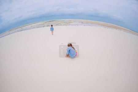 Photo for Two little happy girls have a lot of fun at tropical beach playing together - Royalty Free Image