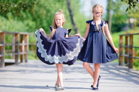 Foto de Adorables niñas de la escuela al aire libre en el cálido día de septiembre. Regreso a la escuela
. - Imagen libre de derechos
