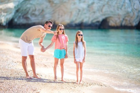 Foto de Feliz hermosa familia de papá y niños en la playa blanca - Imagen libre de derechos