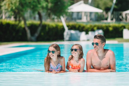 Téléchargez les photos : Heureuse famille de quatre personnes en piscine extérieure - en image libre de droit