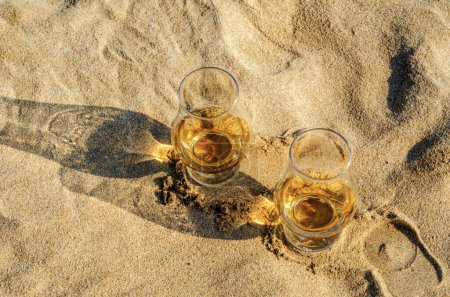 Foto de Vasos de whisky de malta en la playa de arena - Imagen libre de derechos