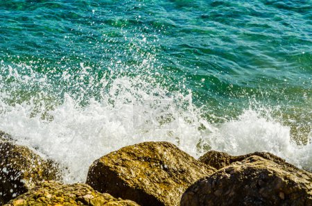 Foto de Agua de mar golpeando una orilla rocosa en un día caluroso - Imagen libre de derechos
