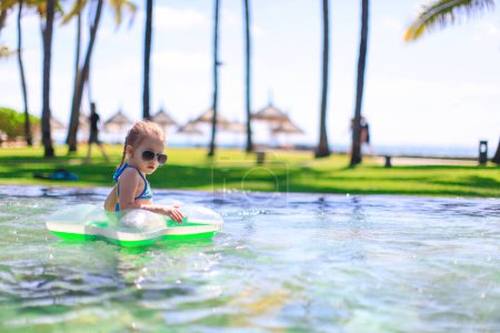 Téléchargez les photos : Petite fille dans la piscine pendant les vacances d'été - en image libre de droit