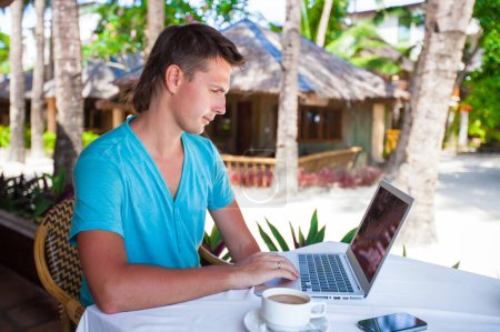 Photo for Young businessman using laptop during summer tropical vacation - Royalty Free Image