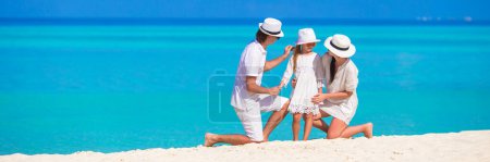 Téléchargez les photos : Jeune Famille sur la plage de sable blanc pendant les vacances d'été - en image libre de droit