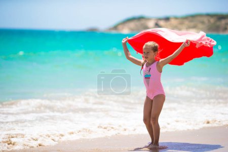 Photo for Little girl have fun with beach towel during tropical vacation - Royalty Free Image