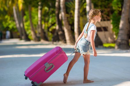 Téléchargez les photos : Petite fille adorable avec de gros bagages sur l'île tropicale - en image libre de droit