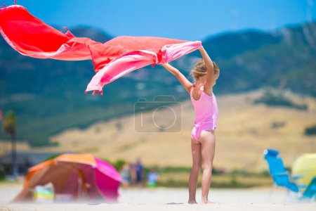 Téléchargez les photos : Petite fille avec serviette de plage pendant les vacances tropicales - en image libre de droit