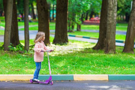 Photo for Adorable little girl have fun on the scooter outdoor - Royalty Free Image