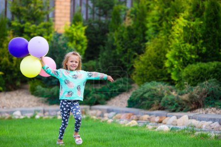 Téléchargez les photos : Bonne petite fille jouant avec des ballons à l'extérieur - en image libre de droit