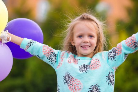 Photo for Portrait of happy little girl playing with balloons outdoors - Royalty Free Image