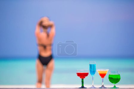 Foto de "Coloridos cócteles exóticos sabrosos en el fondo de la cafetería al aire libre de color turquesa mar y chica
" - Imagen libre de derechos