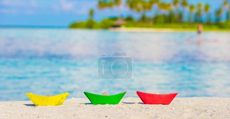 Téléchargez les photos : Bateaux en papier coloré sur la plage de blanc tropical à l'extérieur - en image libre de droit