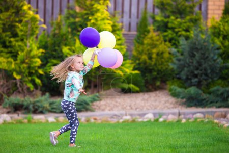 Téléchargez les photos : Bonne petite fille jouant avec des ballons à l'extérieur - en image libre de droit