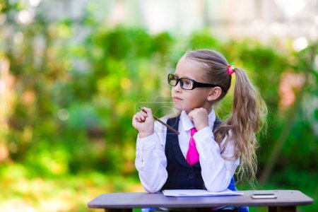 Photo for Adorable little school girl at desk with notes and pencils outdoor. Back to school. - Royalty Free Image