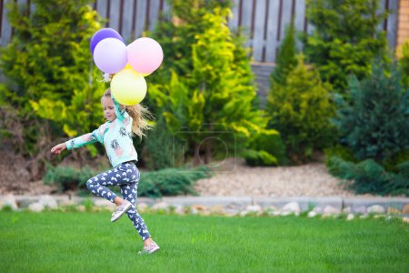 Photo for Happy little girl playing with balloons outdoors - Royalty Free Image