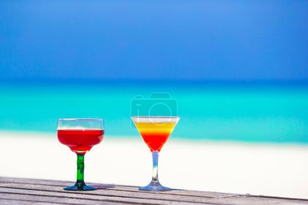 Foto de "Dos sabrosos cócteles en la playa tropical blanca
" - Imagen libre de derechos