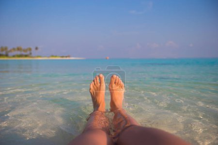 Foto de Pies femeninos en playa de arena blanca y agua clara - Imagen libre de derechos