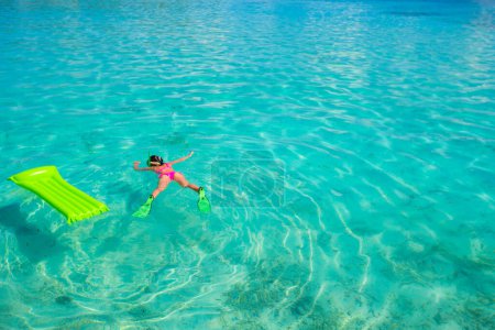 Téléchargez les photos : Matelas gonflable et relaxant femme à l'eau turquoise - en image libre de droit