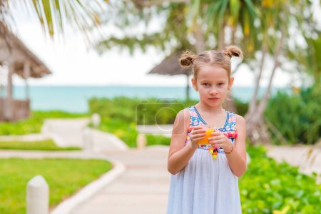 Photo for Adorable little girl with juice at outdoor cafe - Royalty Free Image