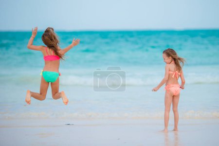 Photo for Little girls playing together at shallow water on vacation - Royalty Free Image