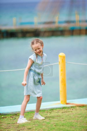 Photo for Little girl at summer vacation at warm day on the wild seashore - Royalty Free Image