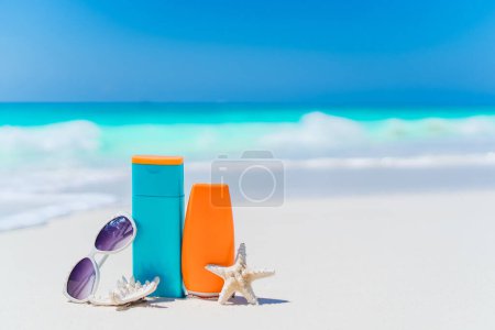 Photo for Suntan lotion bottles and starfish at the beach - Royalty Free Image