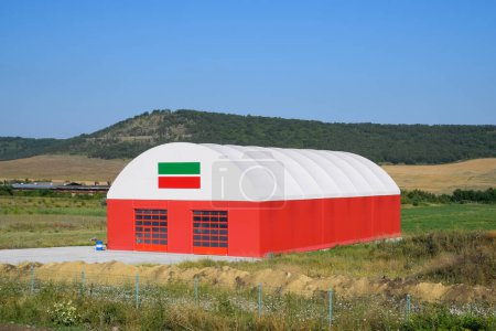 Photo for The hangar is white and red. An hangar in field. - Royalty Free Image